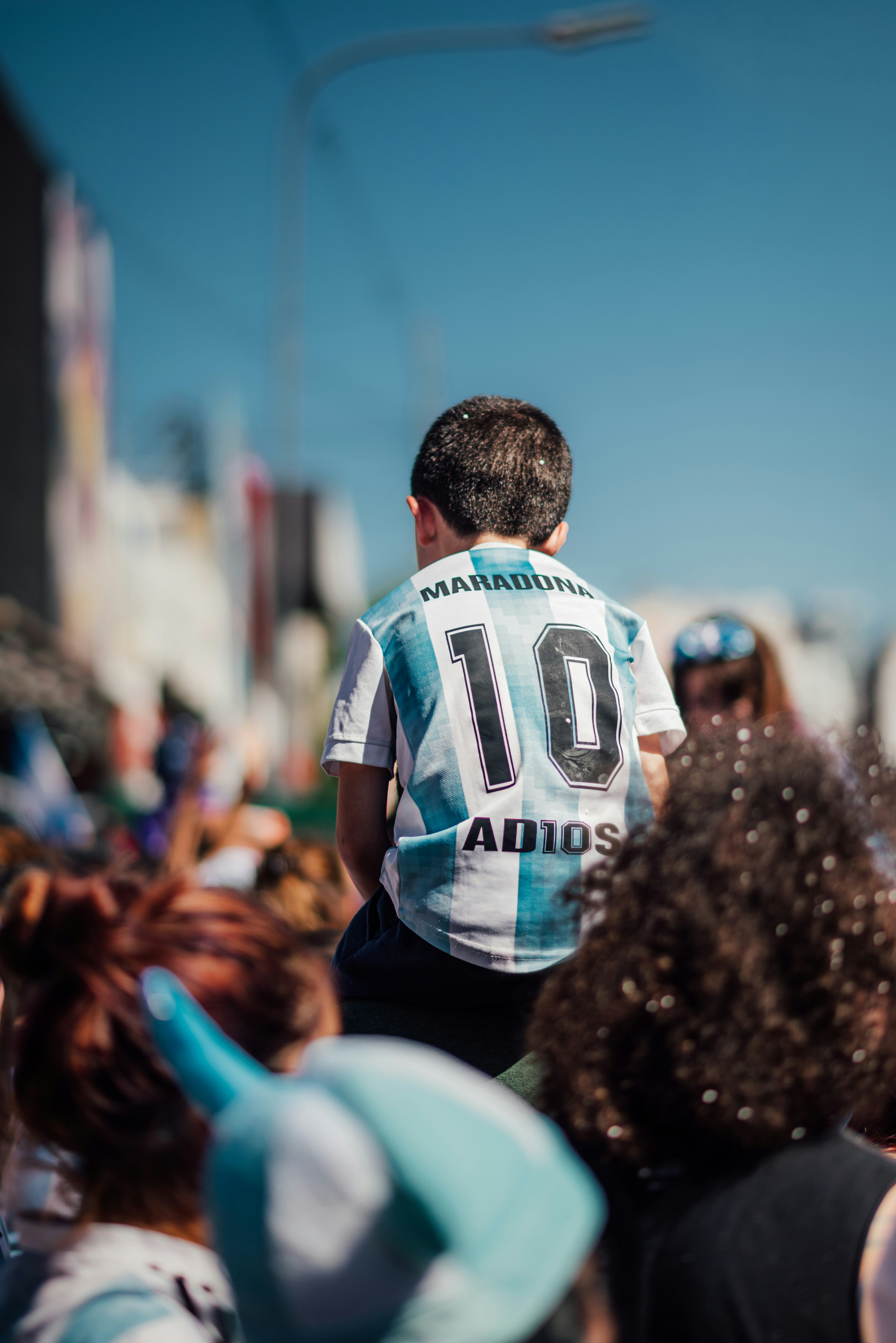 A young Argentine fan in a crowd wearing a Maradona number 10 jersey