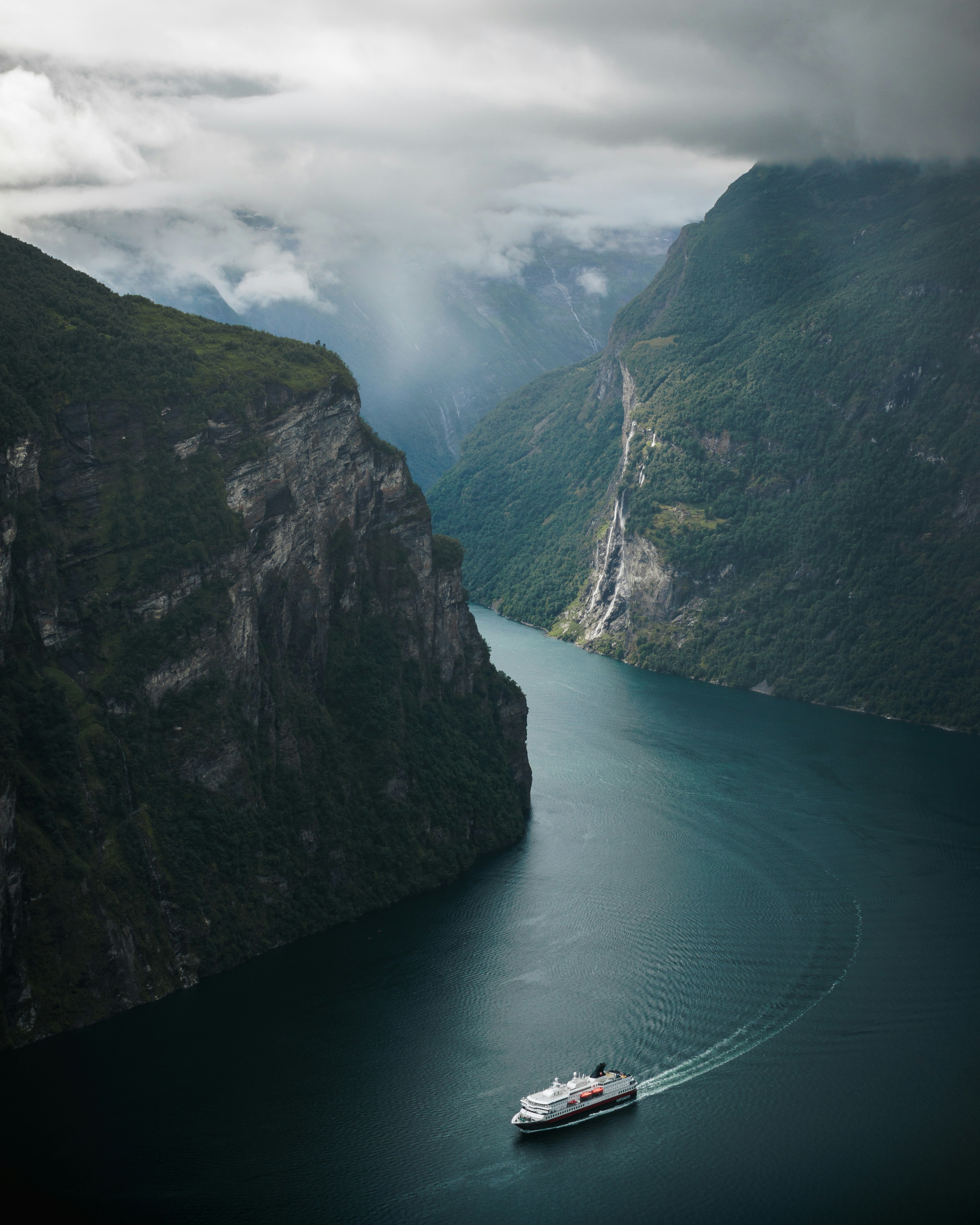 An expedition ship sailing through a Norwegian fjord