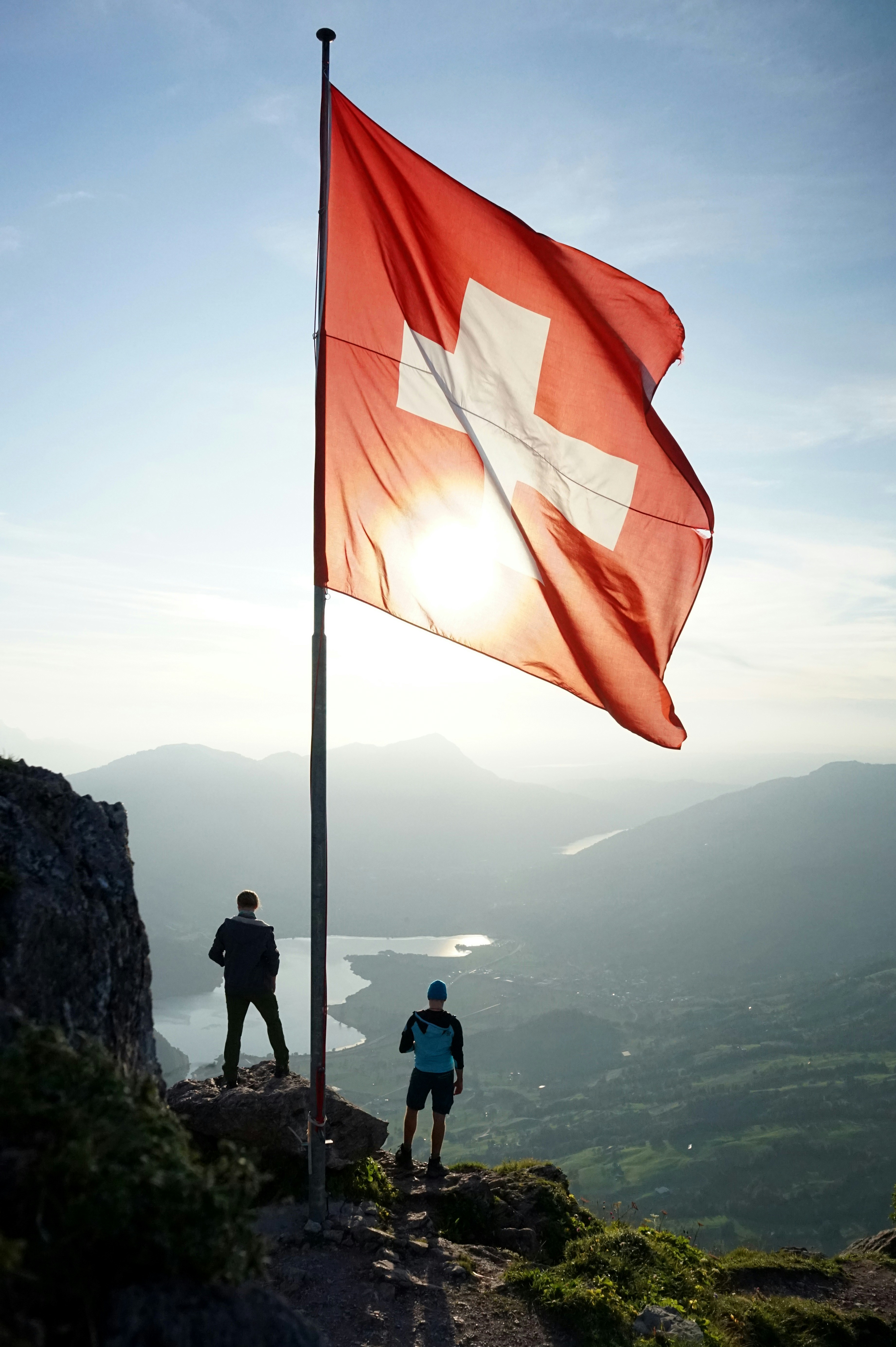 Swiss mountain landscape with the red and white national flag in the foreground
