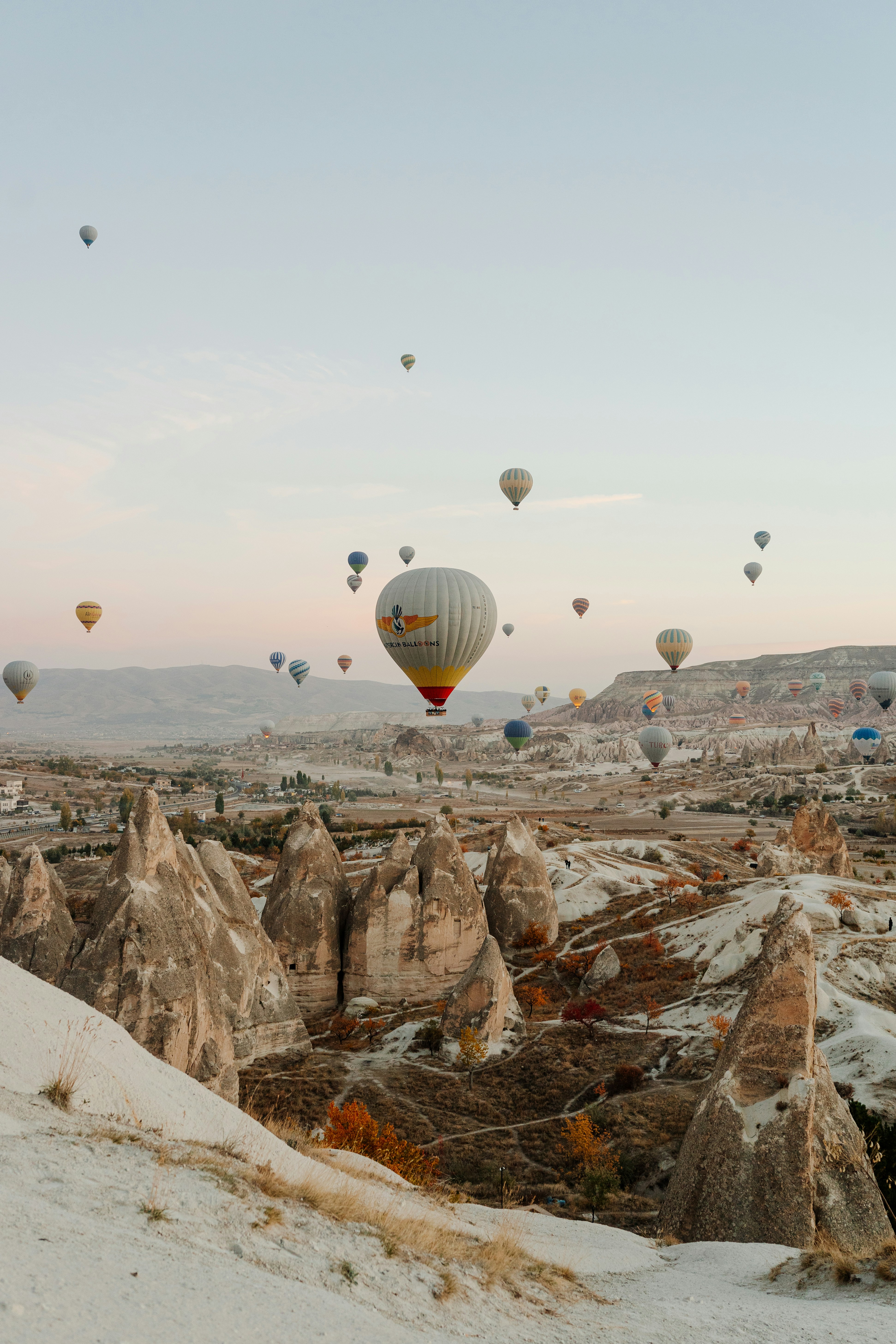 Hot air balloons drifting over the otherworldly landscape of Cappadocia at sunrise