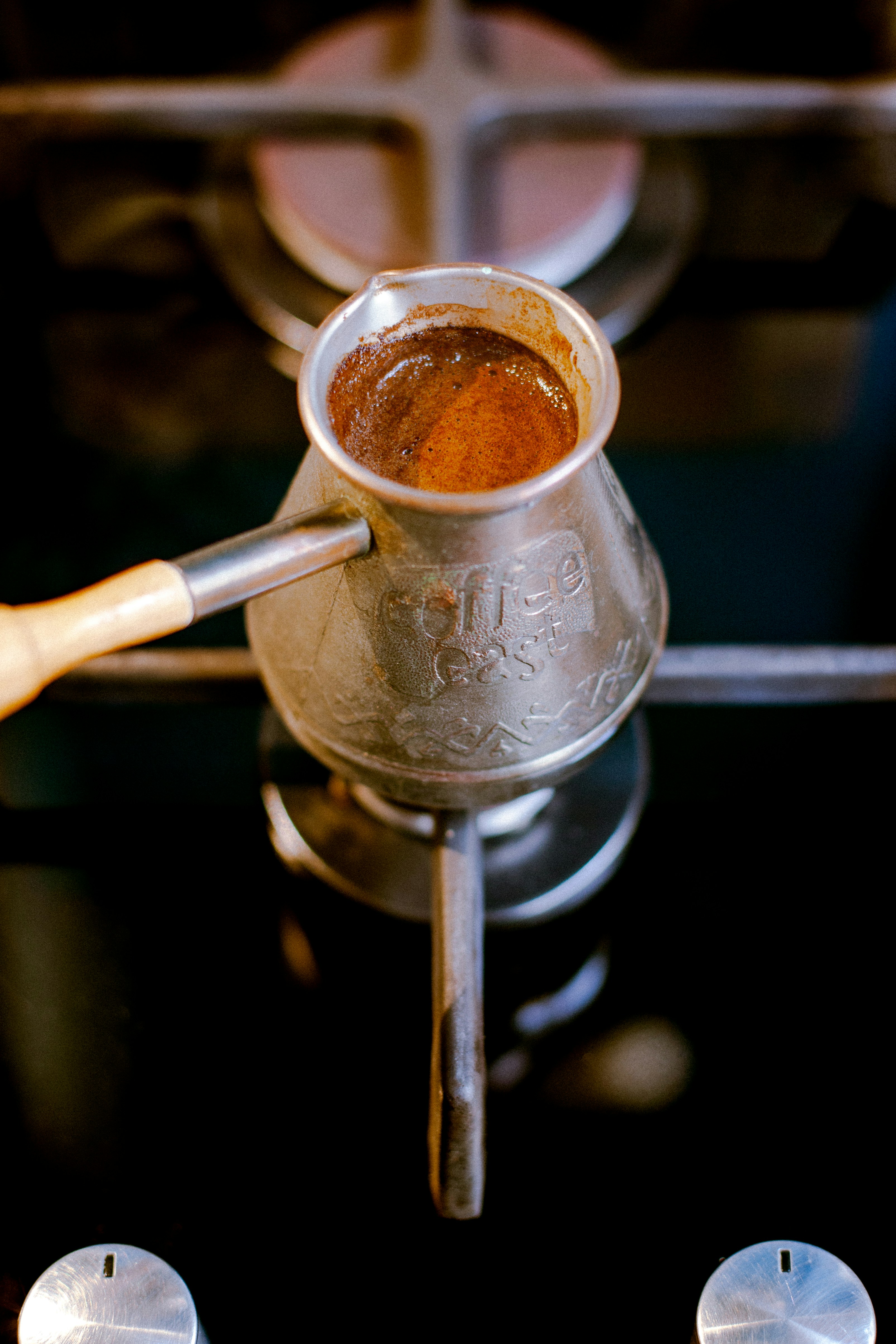 A cup of traditional Turkish coffee served on a small copper tray with a piece of lokum