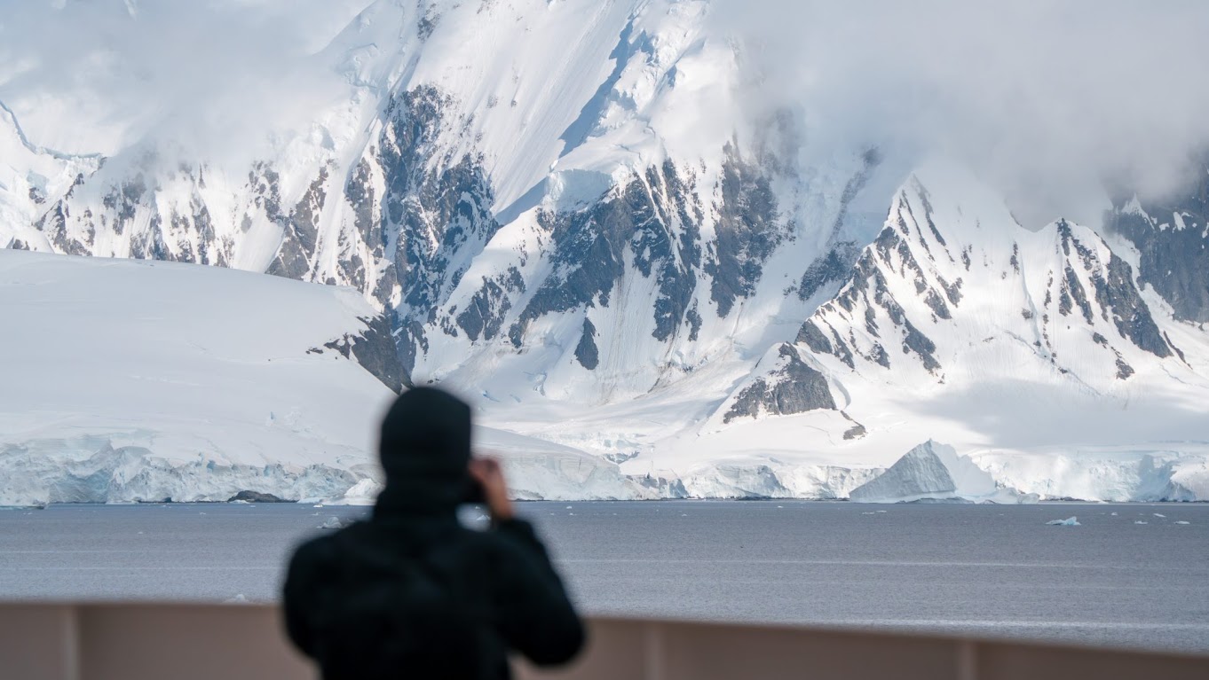 Snow covered peaks rising from dark water at Orne Harbour, Antarctica